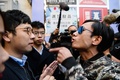 香港立法会（議会）の補欠選挙で、議員資格を剥奪された民主派の羅冠聡（ネイサン・ロー）元議員（左）に詰め寄る男性（右、2018年3月11日撮影）。(c)AFP PHOTO / ANTHONY WALLACE