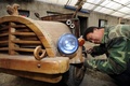 中国北東部の遼寧（Liaoning）省瀋陽（Shenyang）で木製の電気自動車を作る大工の劉福竜（Liu Fulong）さん（2014年10月29日撮影）。(c)AFP