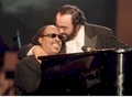 1998年6月9日、モデナ（Modena）で開催されたコンサート「パバロッティと仲間たち（Pavarotti and Friends）」で、スティービー・ワンダー（Stevie Wonder、右）とともにステージに立つルチアーノ・パバロッティ（Luciano Pavarotti、左）。(c)AFP
