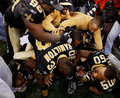 09NFLプレーオフ、ナショナル・カンファレンス（NFC）決勝、ニューオーリンズ・セインツ（%%New Orleans Saints%%）対ミネソタ・バイキングス（%%Minnesota Vikings%%）。試合はセインツが31-28で勝利し、チーム創設以来初のスーパーボウル進出を決めた。写真は決勝点となるフィールドゴールを決めたギャレット・ハートリー（%%Garrett Hartley%%、下）とともに歓喜するセインツの選手。（2010年1月24日撮影）(c)AFP/Chris Graythen