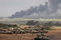 イスラエルのパレスチナ自治区ガザ地区との境界近くの拠点で、戦車の近くに立つイスラエル兵（2024年1月14日撮影）。(c)Menahem KAHANA / AFP