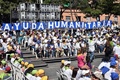 ベネズエラの首都カラカスで行われた野党指導者フアン・グアイド氏の集会で、「人道支援活動」を意味する文字をかかげた支持者ら（2019年2月16日撮影）。(c) YURI CORTEZ / AFP