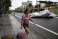 ベトナム中部クアンガイ省で、台風18号通過後にホテルから自宅に戻る女性（2020年10月28日撮影）。(c)MANAN VATSYAYANA / AFP