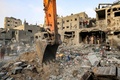 パレスチナ自治区ガザ地区南部ハンユニスで、イスラエル軍の爆撃を受けた建物周辺で生存者と遺体の捜索を行う人々（2023年10月25日撮影）。(c)MAHMUD HAMS / AFP