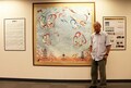 「永遠の敦煌－常書鴻生誕１２０周年記念展」の会場で、自身の作品と写真に収まる常嘉煌氏（2024年9月16日撮影）。(c)Xinhua News