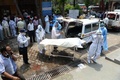 インドの首都ニューデリーにある火葬場で、コロナ犠牲者の遺体を運ぶ防護服姿の作業員（2020年6月3日撮影）。(c)AFP/Sajjad  HUSSAIN