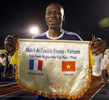 ホーチミン市で行われた親善試合で、試合前に記念旗を掲げる元フランス代表の%%Amara Simba%%氏。(c)AFP