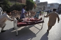 パキスタン・ペシャワル（Peshawar）北方のチャルサダ（Charsadda）地区で起きた2件の爆弾攻撃で負傷し、病院に搬送される男性（2011年5月13日撮影）。(c)AFP/HASHAM AHMED
