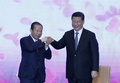 北京の人民大会堂で開かれた日中交流行事で手を取り合う中国の習近平国家主席（右）と二階俊博自民党総務会長（2015年5月23日撮影）。(c)AFP/KIM KYUNG-HOON