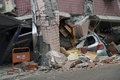台湾東部・花蓮で、地震により損壊した建物の下敷きになった車（2018年2月7日撮影）。(c)AFP PHOTO / PAUL YANG
