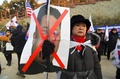 韓国・江陵での北朝鮮楽団の公演を前に、穴を開けた北朝鮮の金正恩労働党委員長の顔写真を持って抗議デモを行う人（2018年2月8日撮影）。(c)AFP PHOTO / JUNG Yeon-Je