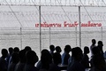 タイのチョンブリ中央刑務所で新型コロナウイルスのワクチン接種を受け、副反応の有無を観察するため待機させられる受刑者ら（2021年6月25日撮影）。(c)Lillian SUWANRUMPHA / AFP