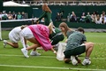 テニス、ウィンブルドン選手権、女子シングルス1回戦。コートにまかれた紙吹雪を拾い集めるダリア・サビル（左奥）、ケイティ・ボールター（左手前）とボールキッズ（2023年7月5日撮影）。(c)Glyn KIRK / AFP