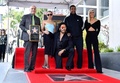 ハリウッドの殿堂入りを果たした米歌手レニー・クラヴィッツ（左）と、駆けつけた娘で俳優のゾーイ・クラヴィッツ（左から2人目）、俳優のデンゼル・ワシントン（右から2人目）ら（2024年3月12日撮影）。(c) VALERIE MACON / AFP