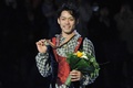 フィギュアスケート世界選手権、男子シングル・フリースケーティング（FS）。表彰台で金メダルを手にポーズをとる高橋大輔（2010年3月25日撮影）(c)Yuri KADOBNOV / AFP