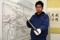 16日、西咸新区空港新城岩村にある秦人の墓で発掘された銅剣の説明をする陜西省考古研究院の張楊力錚・助理研究員（2018年3月16日撮影）。(c)Xinhua News