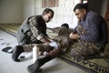 シリア北部ラッカのメシュレブ地区で、負傷した兵士の手当てをするクルド人とアラブ人の合同部隊「シリア民主軍」のメンバーら（2017年6月7日撮影）。(c)AFP/DELIL SOULEIMAN