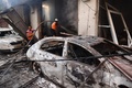 イスラエル軍による人質救出作戦で損傷した建物で消火作業に当たる当局者。パレスチナ自治区ガザ地区中部ヌセイラット避難民キャンプで（2024年6月9日撮影）。(c)EYAD BABA / AFP