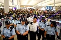 香港空港で、出発ターミナル入り口付近を警備する警察官（2019年8月13日撮影）。(c)Manan VATSYAYANA / AFP