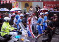 マレーシアのクアラルンプール（Kuala Lumpur）で豪雨の中、地元警官らに囲まれて走る北京五輪の聖火リレー走者（2008年4月21日撮影）。(c)AFP/ROSLAN RAHMAN