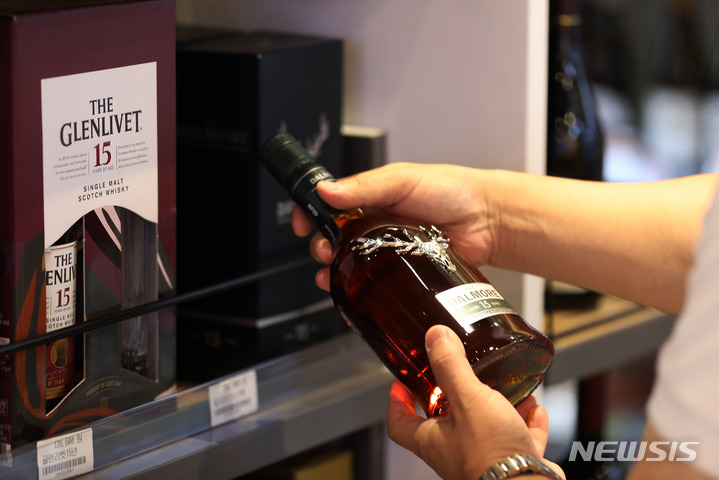 ウイスキーの品定めをする買い物客(c)NEWSIS