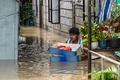 台風16号が通過した後のフィリピン・ブラカン州サンイルデフォンソで、自宅から荷物を持ち出す人（2022年9月26日撮影）。(c)TED ALJIBE / AFP