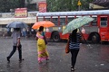 大型サイクロンによる豪雨に見舞われる中、インド西部ムンバイのバスターミナル近くを歩く人々（2021年5月17日撮影）。(c)Indranil MUKHERJEE / AFP
