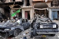 シリア中部ホムスで、2台の自動車爆弾が爆発した現場に並ぶ破壊された車両（2016年2月21日撮影）。(c)AFP