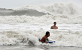 香港の浜辺で、台風の接近するなか、泳ぐ人々（2008年8月22日撮影）。(c)AFP/CONNOR CLARKE