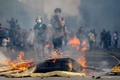 チリの首都サンティアゴで、兵士らと衝突するデモ参加者（2019年10月19日撮影）。(c)Pablo VERA / AFP
