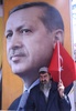 トルコ中部コンヤ（Konya）県で行われた与党・公正発展党（AKP）の選挙集会で、首相の写真の前で国旗を掲げる男性（2014年３月26日撮影、資料写真）。(c)AFP/ADEM ALTAN