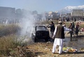 パキスタン北西部・クラム部族地域パラチナルの市場で起きた爆弾事件の現場で、炎上した車両の消火にあたる消防隊員（2015年12月13日撮影）。(c)AFP/M SAQLAIN