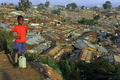 2007年10月23日、ケニヤのスラム街キベラ（Kibera）で、水を入れた容器を置いて休憩する女の子。(c)AFP/Roberto SCHMIDT