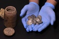 ユダヤ砂漠にあるムラバアト洞窟の発掘現場で見つかった15枚の銀貨。出土した筒（左）の中に入っていた（2022年12月13日撮影）。(c)MENAHEM KAHANA / AFP