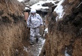 ウクライナ東部ドネツク州ベルヒノトレーツケ村付近の親ロシア分離独立派との前線で、雪に覆われた塹壕を歩くウクライナの兵士（2022年2月1日撮影）。(c)Anatolii STEPANOV / AFP