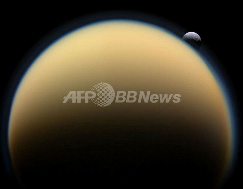 土星の衛星タイタンの背に隠れるテティス