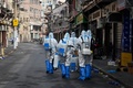 中国・上海の新型コロナウイルス感染者が確認された地区で、消毒剤の散布に向かう保健当局者ら（2021年1月27日撮影）。(c)STR / AFP