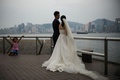 香港で台風4号（ニーダ）が接近する中、ビクトリア湾を望む遊歩道で結婚写真のためポーズをとる新郎新婦（2016年8月1日撮影）。(c)AFP/Anthony WALLACE