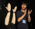 東京・江東区の日本科学未来館（National Museum of Emerging Science and Innovation）で開催中の「デジタルコンテンツエキスポ（Digital Content Expo）」のオープニングで拍手をするロボットアーム「音手（おんず）」と、開発した慶應大学大学院メディアデザイン研究科の高橋征資（Masato Takahashi）さん(2011年10月20日撮影)。(c)AFP/Yoshikazu TSUNO