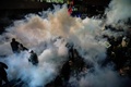 トルコ・イスタンブールにある大手日刊紙ザマン本社前で警察の機動隊から放水銃の水と催涙ガスを浴びせられるデモ参加者ら（2016年3月4日撮影）。(c)AFP/OZAN KOSE