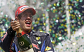 10F1第18戦、ブラジルGP決勝。優勝し、表彰台でシャンパンを振るレッドブルのセバスチャン・ベッテル。（2010年11月7日撮影）(c)AFP/ORLANDO KISSNER