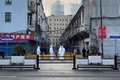 中国・上海の黄浦区で、隔離対象となった住宅街周辺を封鎖する防護服姿の当局者ら（2021年1月21日撮影）。(c)STF / AFP