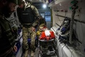 ウクライナ東部ドネツク州バフムート近郊で、負傷したウクライナ兵を応急処置用の移動病院から避難させるボランティアの救急隊員（2022年11月28日撮影）。(c)ANATOLII STEPANOV / AFP