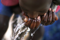 2007年10月20日、ウガンダのOlilim国内避難民キャンプで、井戸から水を飲む女の子。(c)AFP/Roberto SCHMIDT