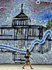韓国ソウル（Seoul）市内の建設現場で、はがき大のパーツからなる絵画の描かれた仮囲いの前を通り過ぎる歩行者（2008年7月11日撮影）。(c)AFP/Jewel SAMAD