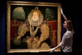 英ロンドンの国立海洋博物館に展示された、エリザベス1世を描いた「アルマダの肖像画」の横でポーズを取る博物館職員（2016年7月29日撮影）。(c)AFP/JUSTIN TALLIS