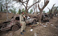 車両による自爆テロの被害に遭ったパキスタンの首都イスラマバード（Islamabad）のマリオットホテル（Marriott Hotel）前で、車の残がいのなか警備するパキスタン軍兵士（2008年9月21日撮影）。(c)AFP/Aamir QURESHI