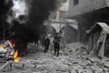 シリア政府軍とロシア軍によるものとされる爆撃があったシリア首都ダマスカス近郊の東グータで、負傷した女性を抱えて歩く男性（2018年1月6日撮影）。(c)AFP PHOTO / ABDULMONAM EASSA