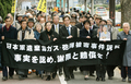 写真は13日、東京高裁前で行進する原告団の支援グループ。(c)AFP/Kazuhiro NOGI