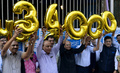 インド・ムンバイ証券取引所（BSE）の主要株価指数SENSEXが3万4000の節目を初めて突破したことを祝って、風船を掲げる職員ら（2017年12月26日撮影）。(c)AFP PHOTO / PUNIT PARANJPE